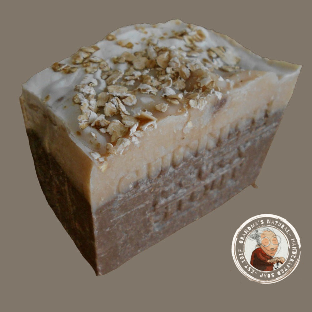 Guinness beer soap, features layers of dark brown, light brown, and beige with "STOUT GUINNESS" embossed on it. The rough-textured soap includes oatmeal pieces embedded in the beige layer at the bottom and helps soften your skin.